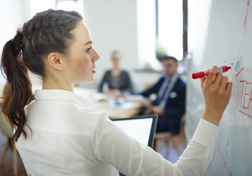 femme-qui-écrit-sur-un-tableau